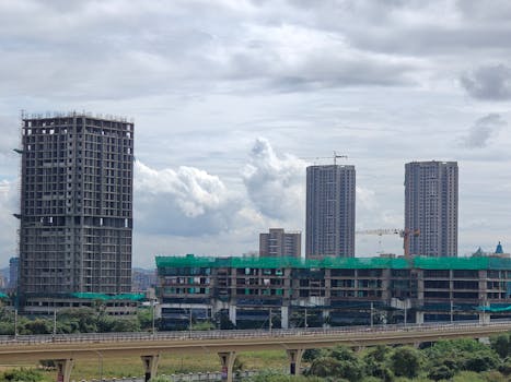 Cityscape featuring high-rise buildings under construction with cranes.